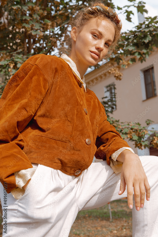 Fototapeta premium Portrait of a beautiful girl walking on the street in stylish clothes 