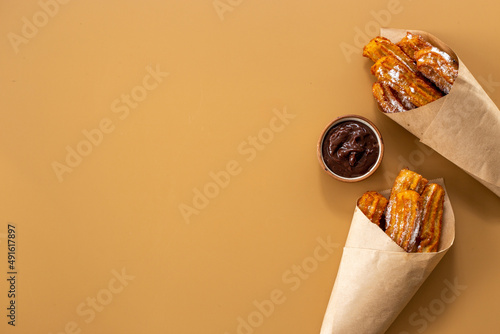 Street food dessert churros in paper bag with sugar photo