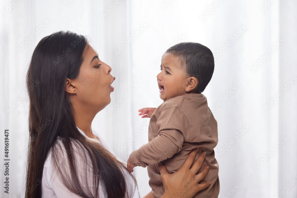 Portrait of a mother calming her crying baby Portrait of a mother calming her crying baby
