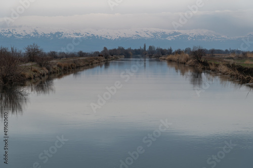 Fototapeta Naklejka Na Ścianę i Meble -  serene expanse of the river with mountain hills on the horizon