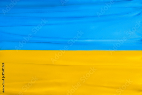 Blue and yellow silk flag of Ukraine. State symbols of Ukraine. Close-up, selective focus, background