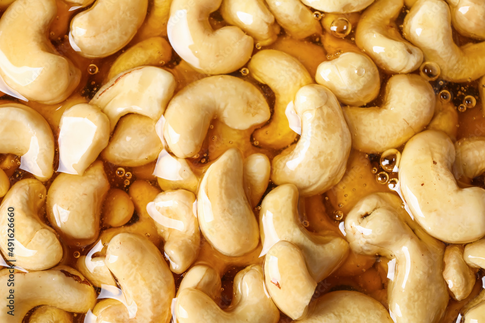 Sweet cashew nuts in honey as background Sweet cashew nuts in honey as background