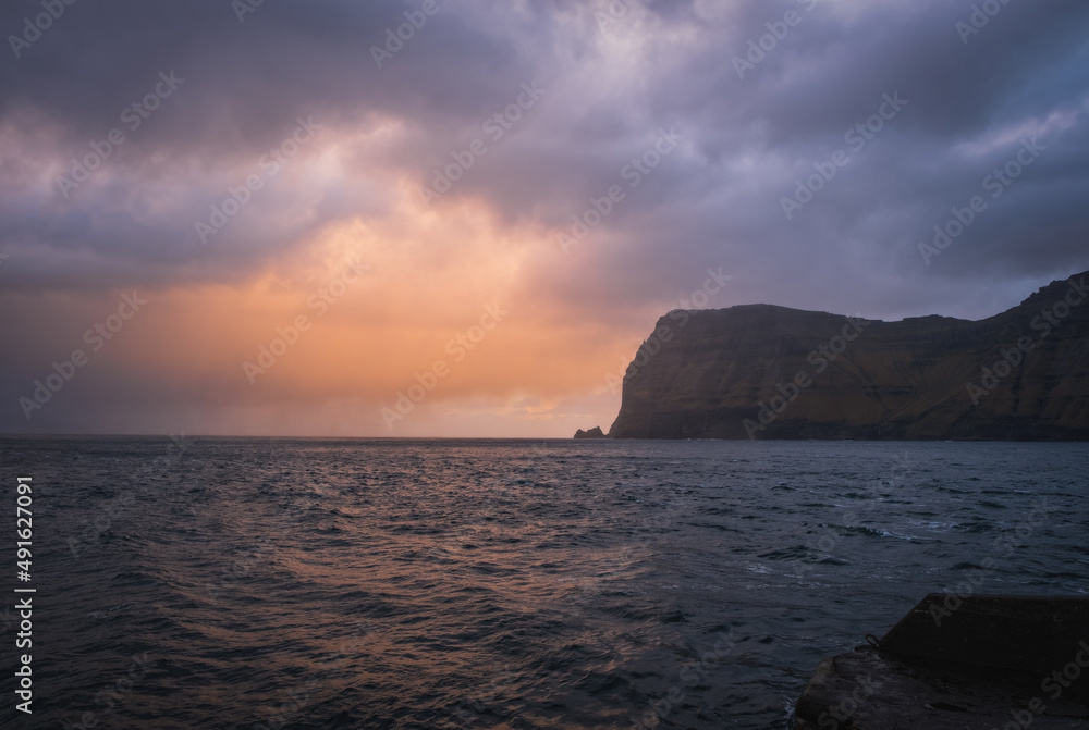 Mikladalur, Kalsoy, an island in the north-east of the Faroe Islands. Ocean and mountain at sunrise time. November 2021