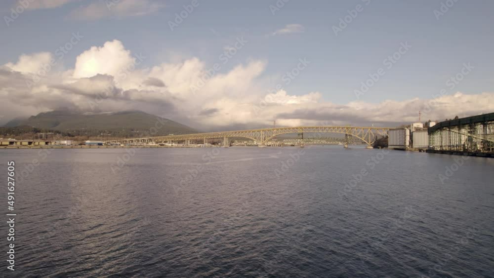 Drone flying over Burrard Inlet waters with Ironworkers Memorial Bridge in background, Vancouver in Canada. Aerial forward Drone flying over Burrard Inlet waters with Ironworkers Memorial Bridge in background, Vancouver in Canada. Aerial forward