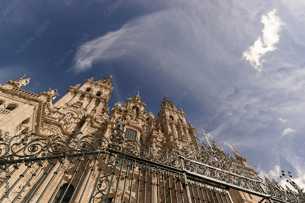 Cathedral of Santiago de Compostela facade in Obradoiro square with blue sky and clouds