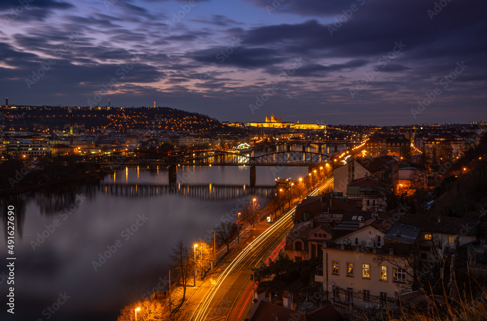 Dreamy night view of Vltava river with magical sky and lights from streets and bridges on sundown behind the Prague Castle in the Old Town of amazing historic city Prague, Czech Republic, Europe.