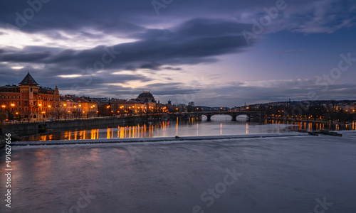 Dreamy night view of Vltava river with magical sky and lights from streets on early morning from the Charles Bridge in the Old Town of amazing historic city Prague, Czech Republic, Europe.