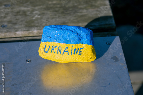 Stone painted with the same colors as the Ukrainian flag and with Ukraine written on it