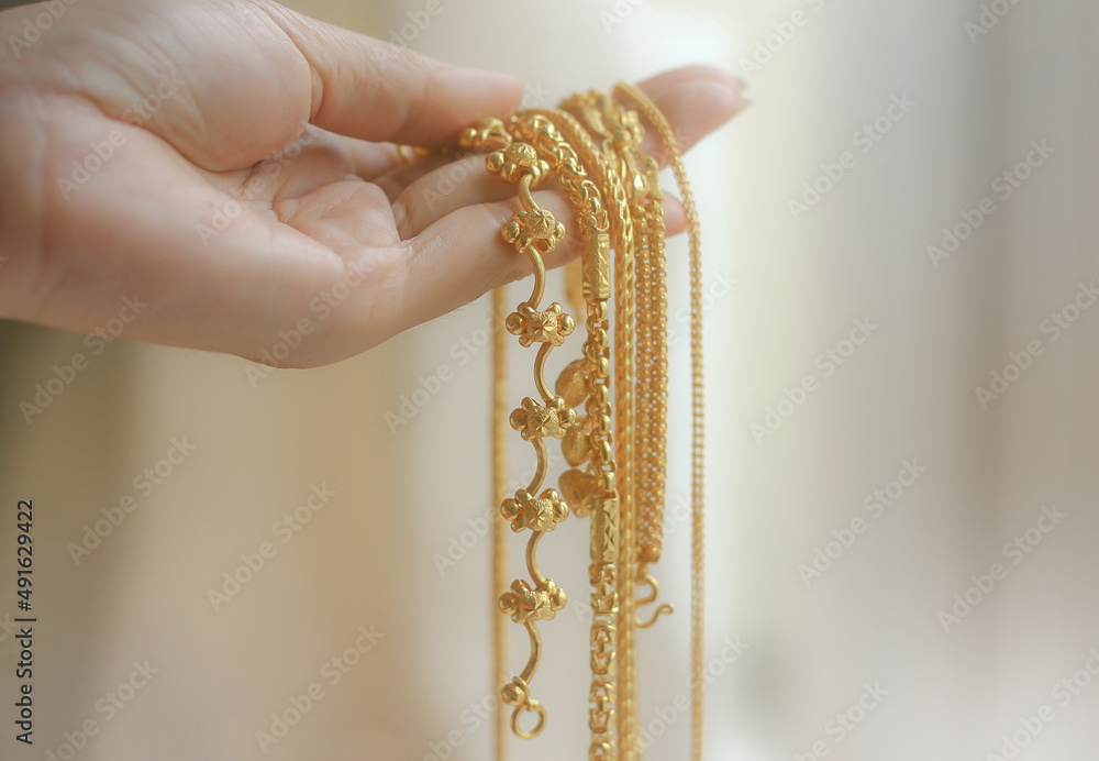 The price of gold has risen greatly. Hand Holding Expensive Gold Necklace