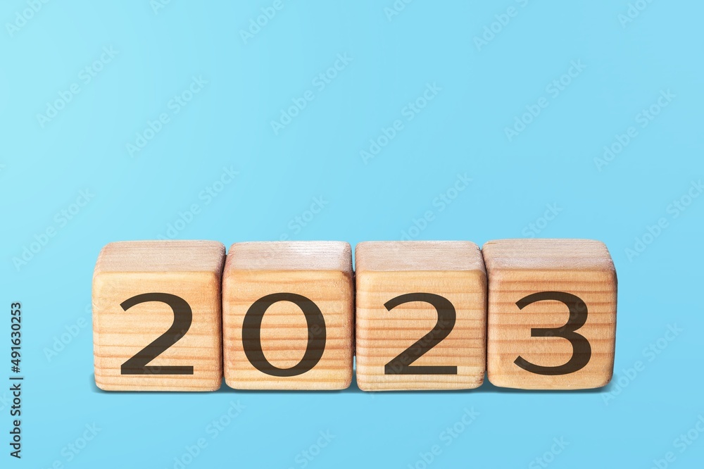 Flipping wooden cubes 2022 to 2023 with blue background. Happy new year 2023. Flipping wooden cubes 2022 to 2023 with blue background. Happy new year 2023.