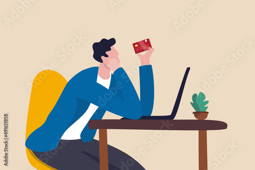 Credit card online payment, e-commerce or internet shopping concept, contemplation man looking at his credit card about to using it to buy things online.