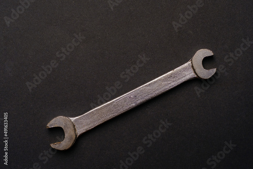 old metallic wrench in black background. High quality photo © Maxim