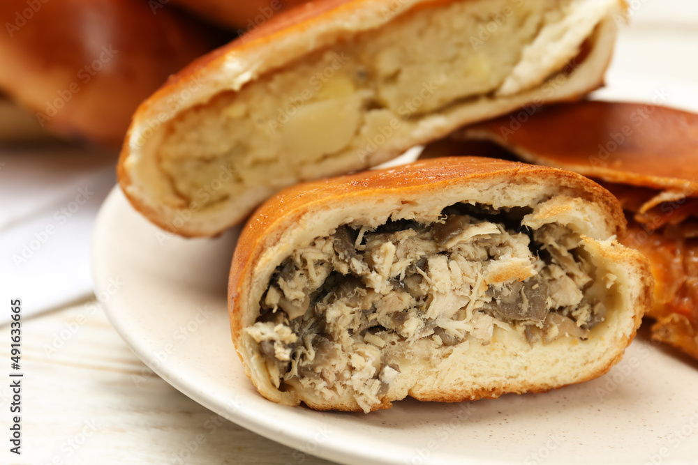 Delicious baked patties with meat and mushrooms on white wooden table, closeup Delicious baked patties with meat and mushrooms on white wooden table, closeup