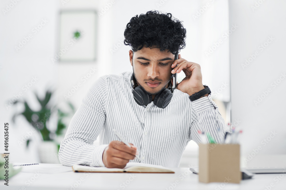 Can you repeat that please. Shot of a young businessman writing notes while talking on a cellphone in an office. Can you repeat that please. Shot of a young businessman writing notes while talking on a cellphone in an office.