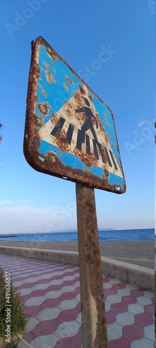 Crosswalk sign. Road sign. Rusty traffic sign.