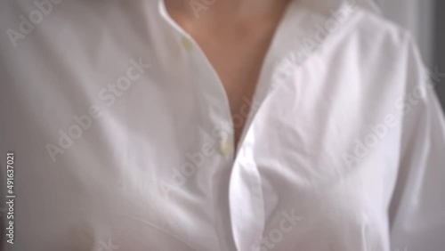 An unrecognizable white woman unbuttons her shirt and exposes her bra. Preparation for breast examination or before sex. Sexy blonde. Sexy slim woman. hands of a woman in close-up.