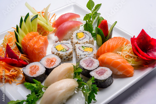 Japanese food mix including sushi and sashimi on white plate.