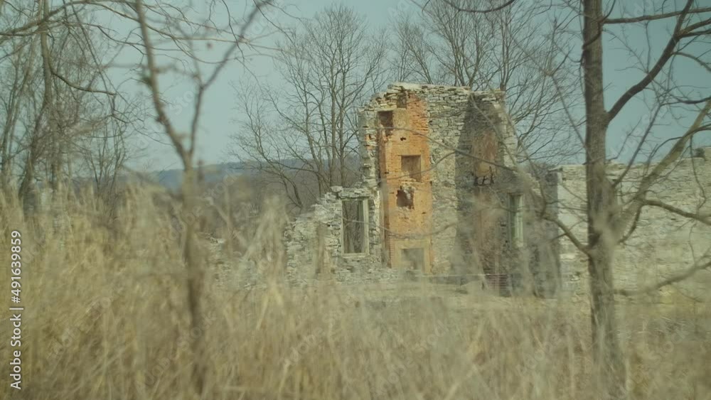 Old abandoned crumbling building through trees and weeds in the countryside Old abandoned crumbling building through trees and weeds in the countryside