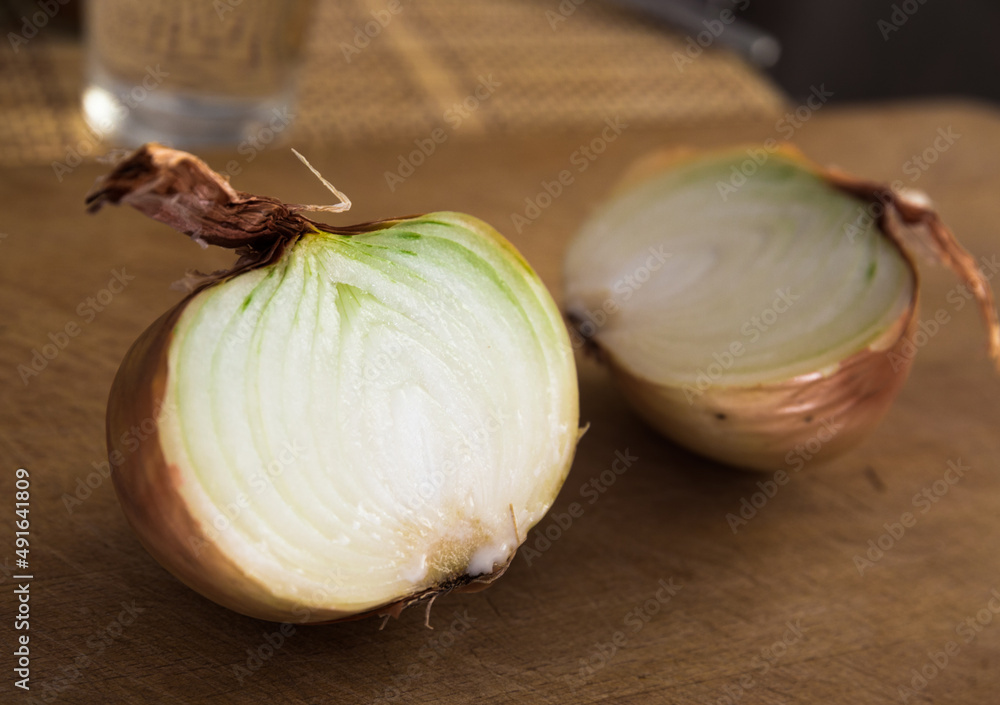Obraz premium halves of ripe onions on wooden board
