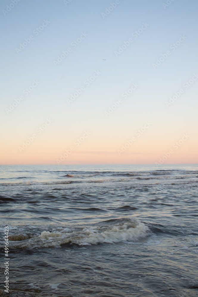 Seascape at sunset. Minimalistic cold sea view at sunset. Clear sky, horizon over water