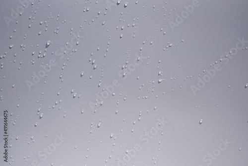 Close up of water drops on white tone background. Abstract white wet texture with bubbles on plastic PVC surface or grunge. Realistic pure water droplets condensed. Detail of canvas leather texture