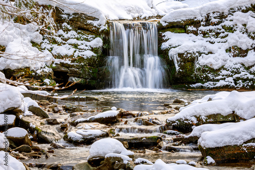 Fototapeta Naklejka Na Ścianę i Meble -  Scenic waterfall covered by snow during winter