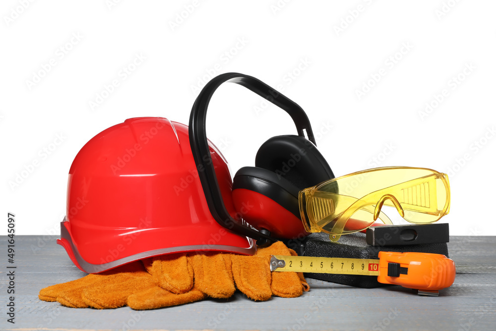Set with safety equipment and tools on wooden table against white background Set with safety equipment and tools on wooden table against white background