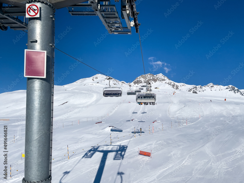 Fototapeta premium ride in the chairlift over white slopes in the deserted ski area