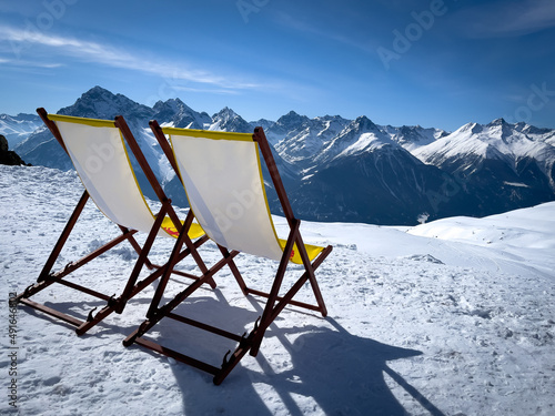 two yellow deck chairs are on the snow Fototapet