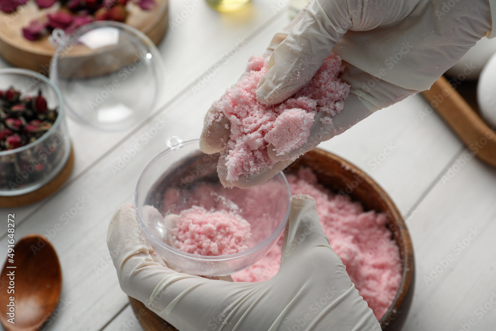 Woman in gloves making bath bomb at white table, closeup Woman in gloves making bath bomb at white table, closeup