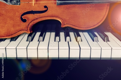 Violin on top of piano keyboard background for music concept