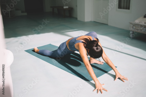 Brunette girl practicing yoga at spacious home