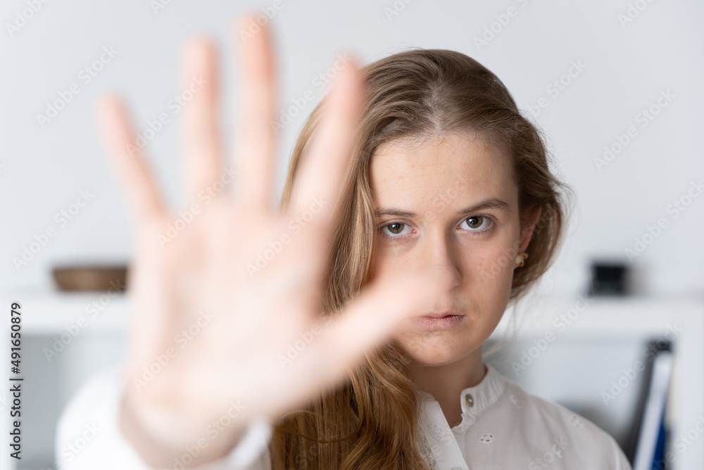 Serious teenager looking at camera and making stop sign. Domestic violence and sexual assault concept Serious teenager looking at camera and making stop sign. Domestic violence and sexual assault concept