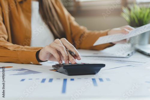 Close up hand of stress asian young employee business woman calculate tax income and expenses, bills, credit card for payment or payday on table at home office. Financial, finance people concept. photo