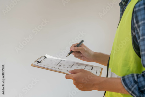 Building inspection, contractor asian young man, male inspecting home, reconstructed construction, renovation or check defect, before finish handing it over to client. Engineering worker, copy space.