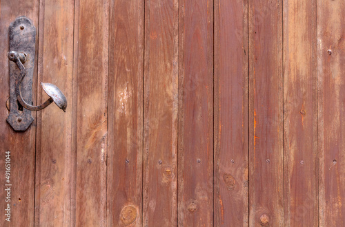 Old wooden door with metal handle, close up view. Background.