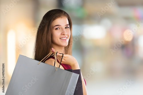 Happy lovely lady with shopping bag posing on background