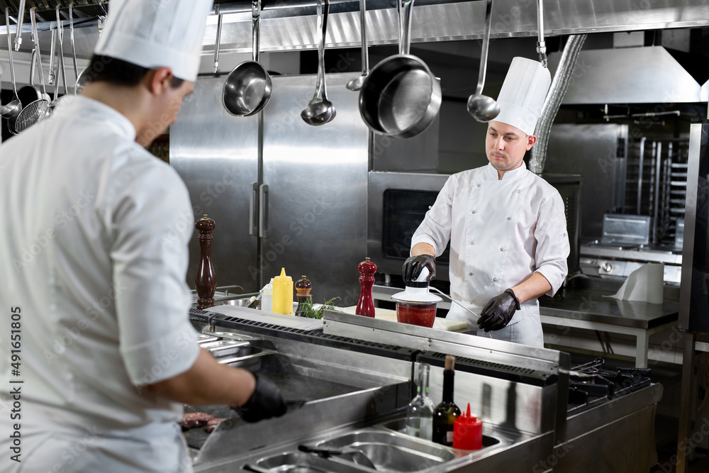 Modern kitchen. Chefs prepare dishes on the stove in the kitchen of a restaurant or hotel. Modern kitchen. Chefs prepare dishes on the stove in the kitchen of a restaurant or hotel.