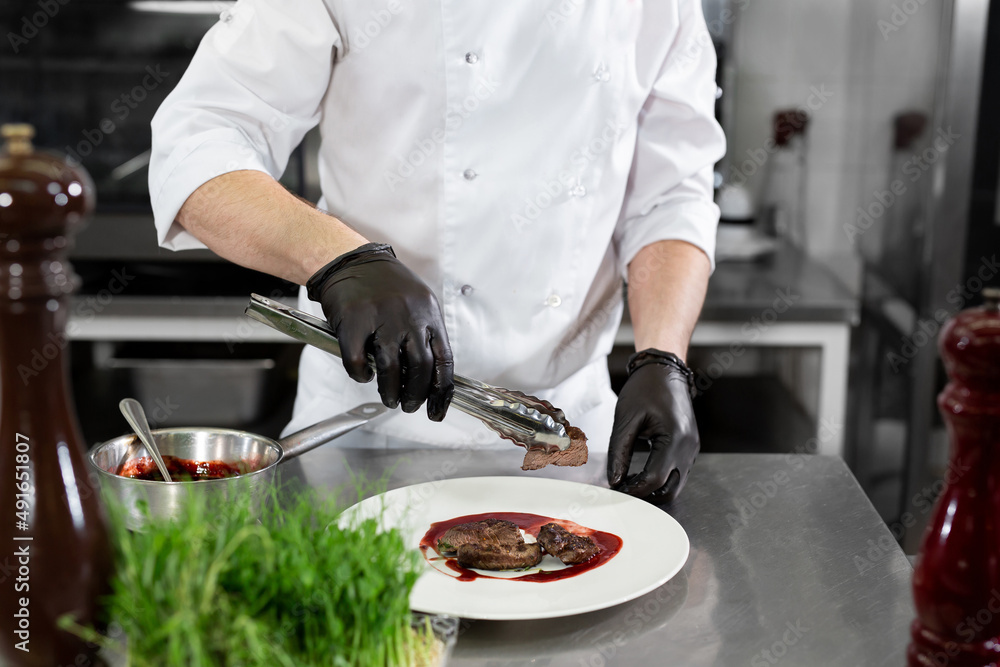 Cook places the medallions on a plate of red sauce Cook places the medallions on a plate of red sauce