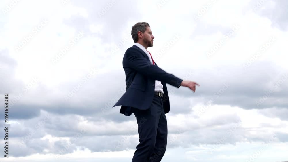 Successful man boss in formal suit dance in cloudy sky, freedom Successful man boss in formal suit dance in cloudy sky, freedom