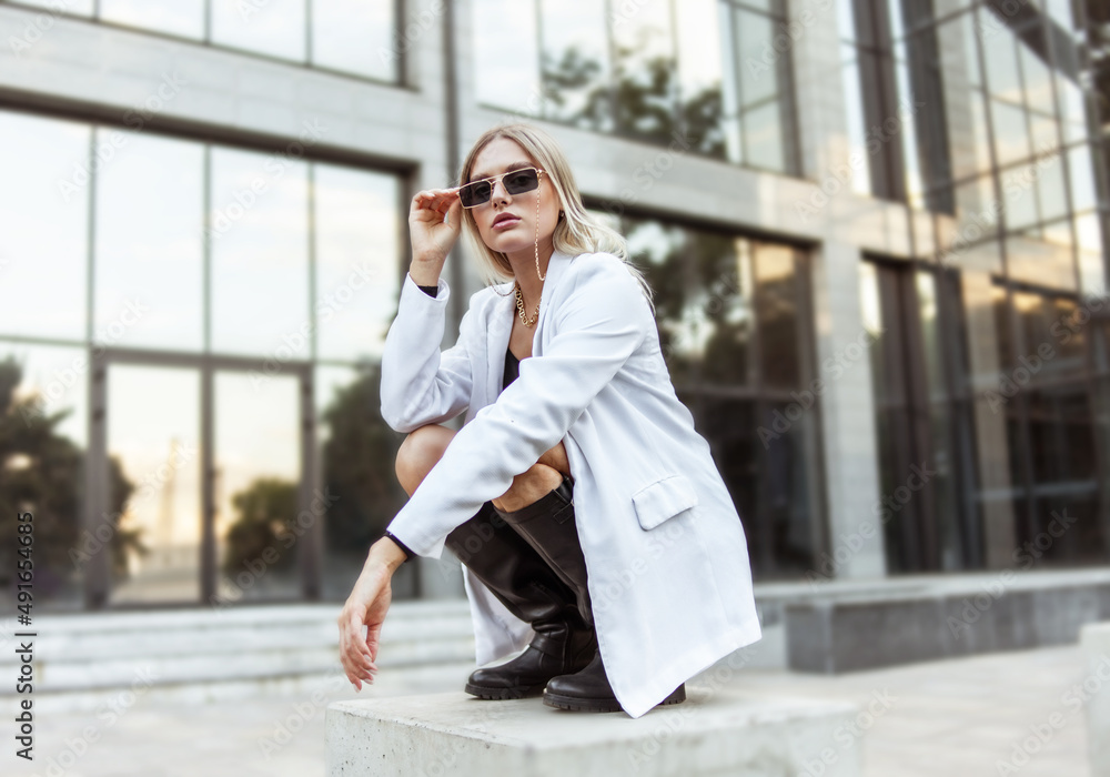 Fototapeta premium Young fashion blonde woman in trendy outfit posing in the city. Street fashion