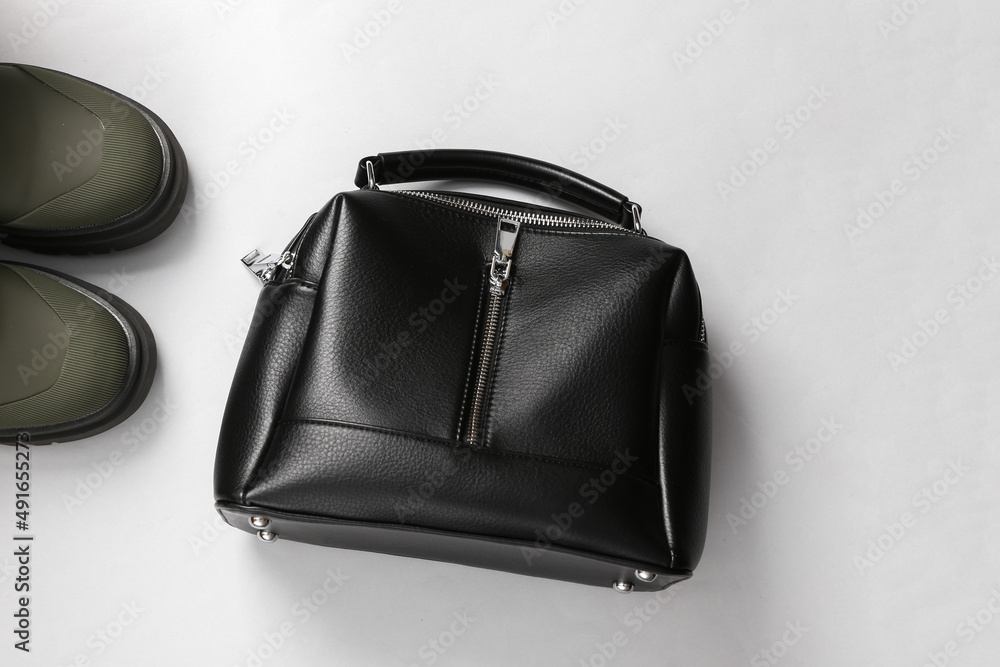 Rubber fashion boots with leather bag on gray background Rubber fashion boots with leather bag on gray background