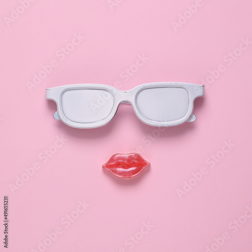 White glasses and lips in the shape of face on pink background. Concept pop, Contemporary still life, minimal layout © splitov27