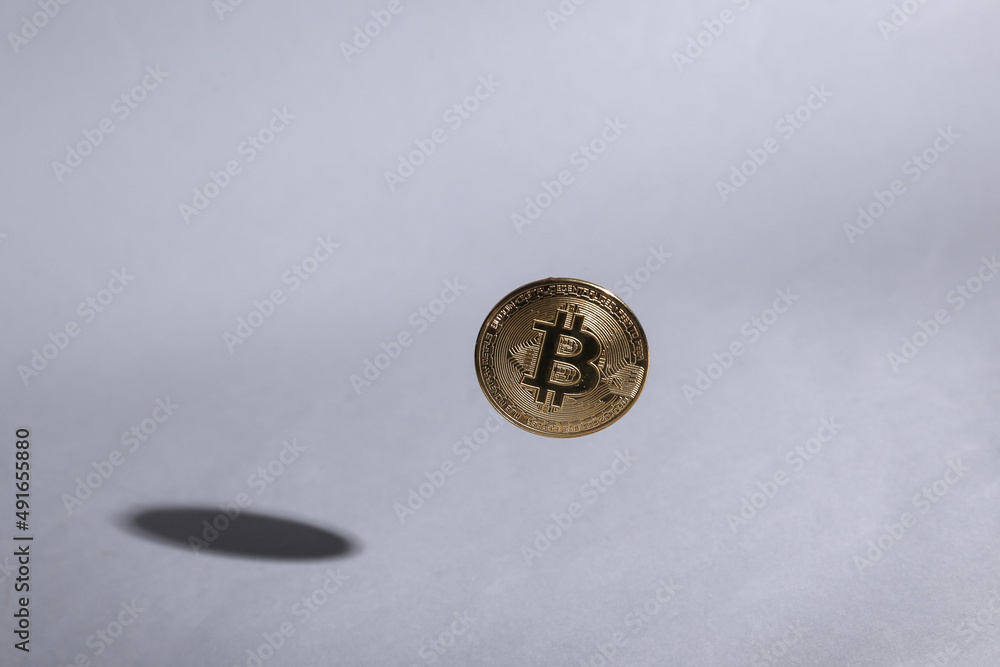 Bitcoin coin soaring on gray background with shadow Bitcoin coin soaring on gray background with shadow