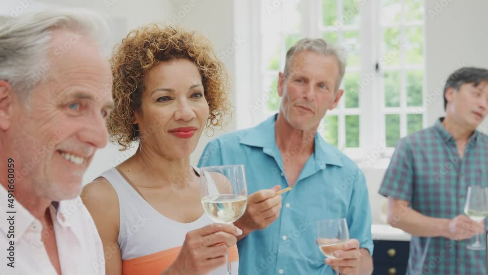 Group of multi-cultural seniors friends on summer vacation meeting for drinks and snacks in holiday apartment - shot in slow motion Group of multi-cultural seniors friends on summer vacation meeting for drinks and snacks in holiday apartment - shot in slow motion