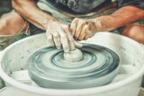 Potter wheel and potter hands, skilled hands of potter shaping the clay.