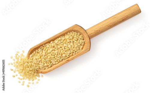 Hulled hemp seeds in the wooden scoop, isolated on the white background, top view.