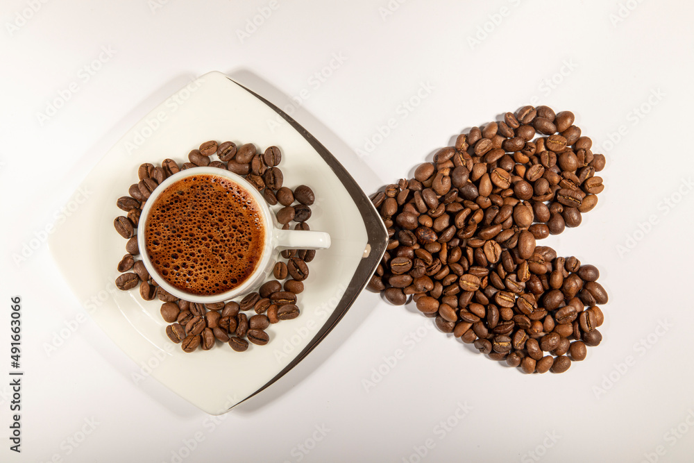 Heart shape made from coffee beans with a cup of coffee on white space. Heart shape made from coffee beans with a cup of coffee on white space.