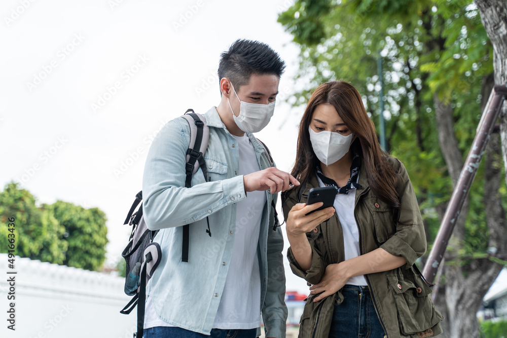 Asian romantic couple wear mask, travel in the city for honeymoon trip. Asian romantic couple wear mask, travel in the city for honeymoon trip.