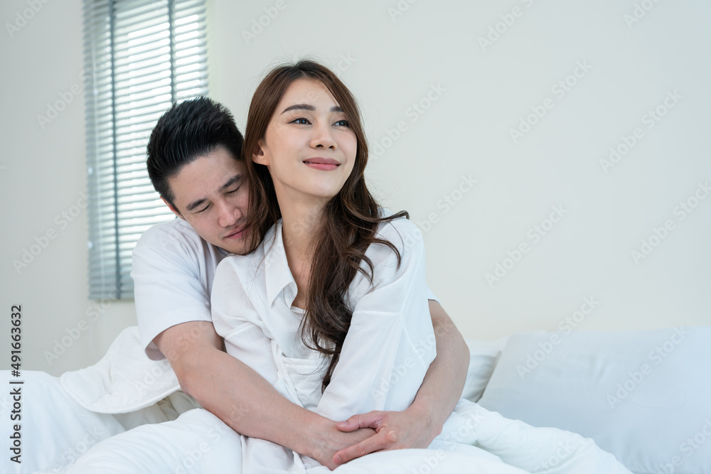Asian new marriage couple sit on bed and hug at each other with love. Asian new marriage couple sit on bed and hug at each other with love.